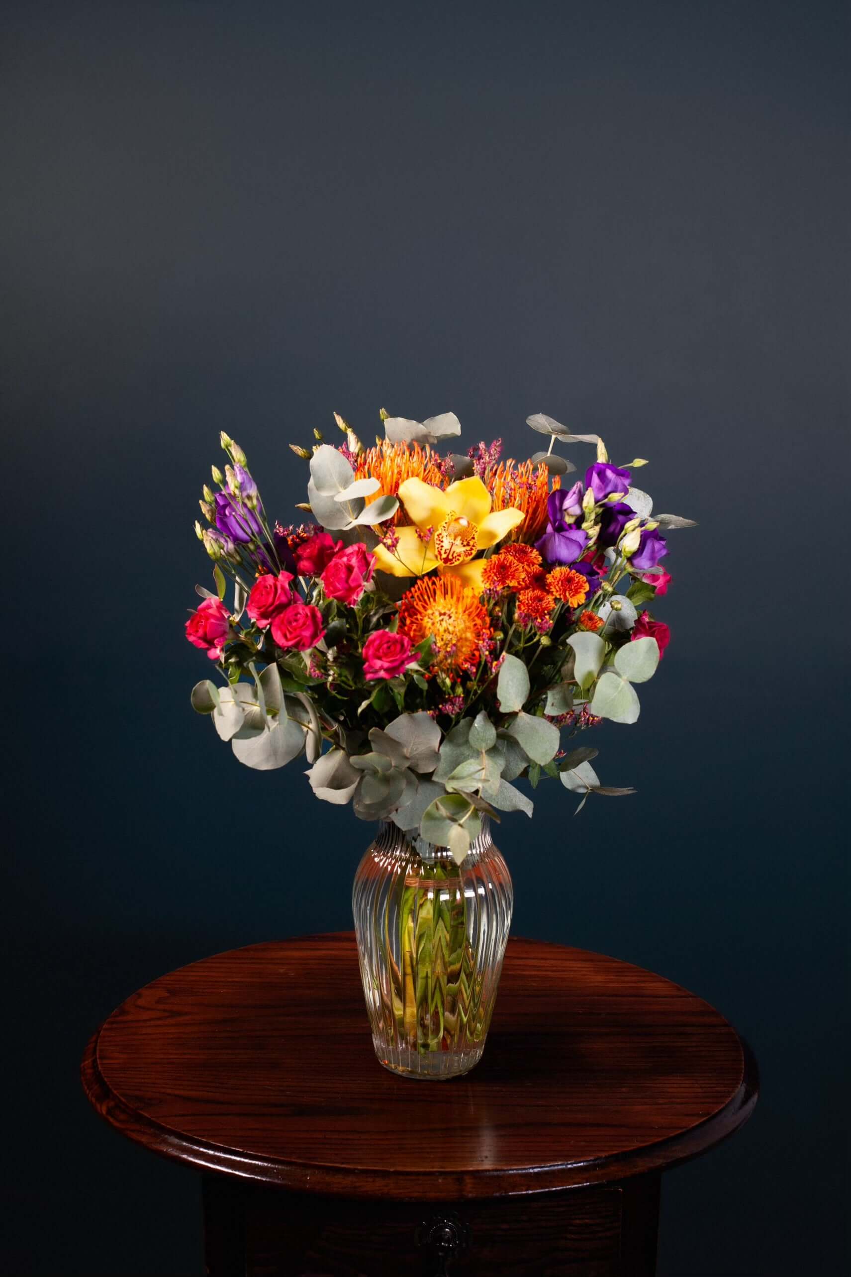 bright vibrant flowers colourful orange tropical cerise purple green yellow mixed bouquet vase
